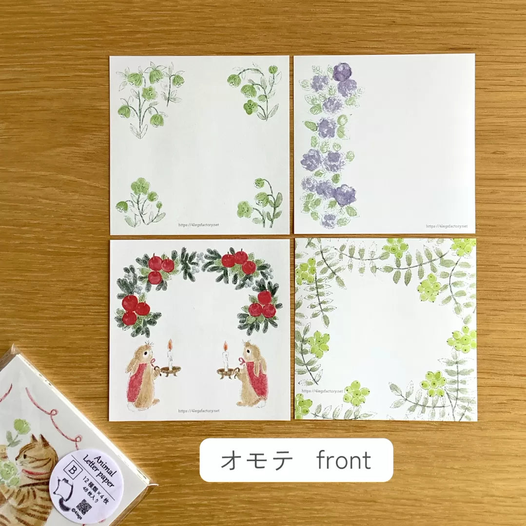 4legs Animal Letter Paper Set B (48 sheets) Set of four cards with floral and nature-themed designs on a wooden surface.