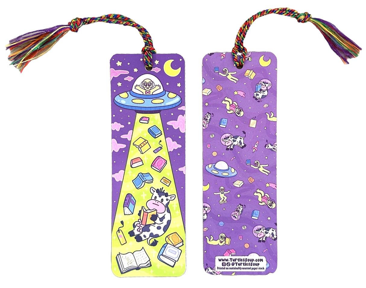 'Alien Abduction Bookmark by Turtle's Soup. Libraries beware! This nerdy alien is abducting every book in town! He loves reading the unique stories that fill planet Earth. His abduction beam has a wide range, so he might accidentally pick up some life forms as well. Hopefully, they don’t mind reading among the stars with him!
Hold your spot in style with our fun and funky bookmark collection! Whether you prefer romance, fantasy, or science fiction, our bookmarks will fit perfectly between the pages of your
