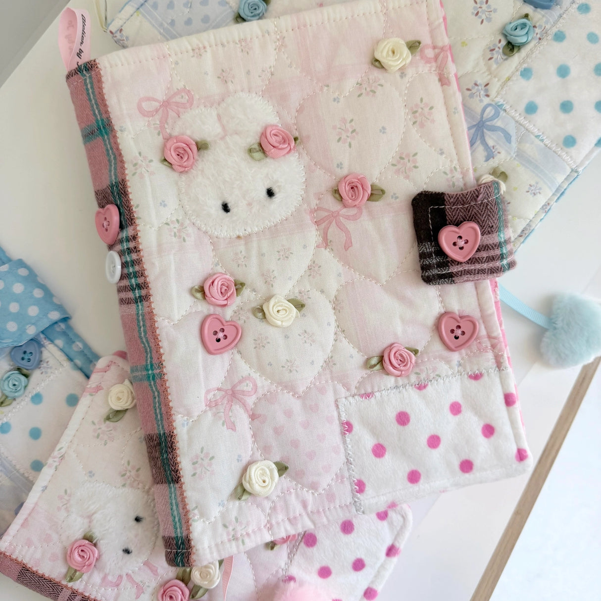 Elevate your journaling experience with these soft and cozy journal covers, designed to protect and personalize your daily diary. Each cover features beautiful blue and pink patterned fabric with thoughtfully sewn details and a secure metal button clasp to keep your pages safe. Includes matching ribbon bookmarks for easy navigation. Available in both A5 and A6 sizes to fit your preferred journal dimensions. The perfect companion for your daily routine and creative practice.