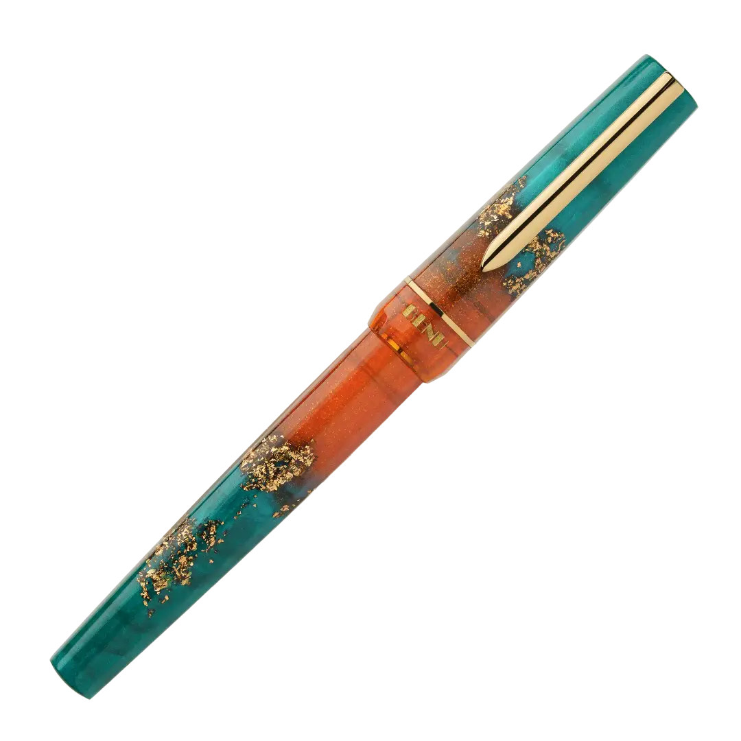 BENU presents the newest Haute Collection — a line of elegant, fashion-inspired pens that blend classic charm with bold, modern flair. The designs include both subtle and vibrant styles, showcasing BENU’s signature glitter and color artistry. Each pen features a faceted body with alternating wide and slender facets, complemented by either gold-plated or chrome-plated trims for a sleek, timeless look.
With a bold orange and teal body streaked with gold, Chic turns heads with runway-ready style. Fashion-forw