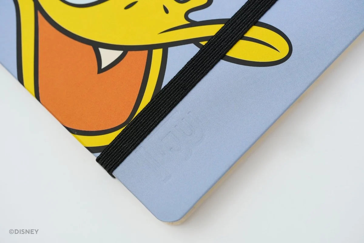 This medium notebook includes 160 pages of 100GSM blank paper and a matte hardcover featuring Donald Duck and Daisy Duck. It also has a built-in pencil holster that comes loaded with a Donald Duck Blackwing pencil.