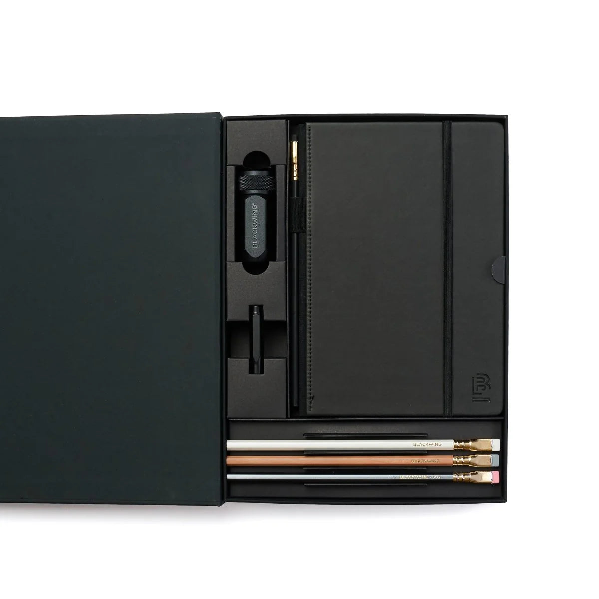 A great way to get started on the Blackwing journey. Give the gift of high-quality Blackwing pencils, paper & accessories — all in one box set.
Includes a Medium Black A5 Slate Notebook, each of our core pencils (602, Matte, Pearl, Natural), One-Step Long Point Sharpener, and Point Guard -- all packaged in a box set.