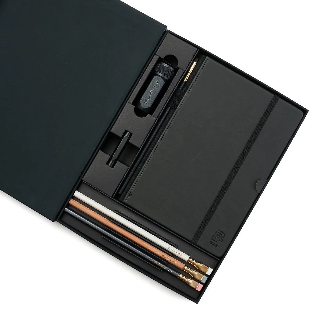 A great way to get started on the Blackwing journey. Give the gift of high-quality Blackwing pencils, paper & accessories — all in one box set.
Includes a Medium Black A5 Slate Notebook, each of our core pencils (602, Matte, Pearl, Natural), One-Step Long Point Sharpener, and Point Guard -- all packaged in a box set.