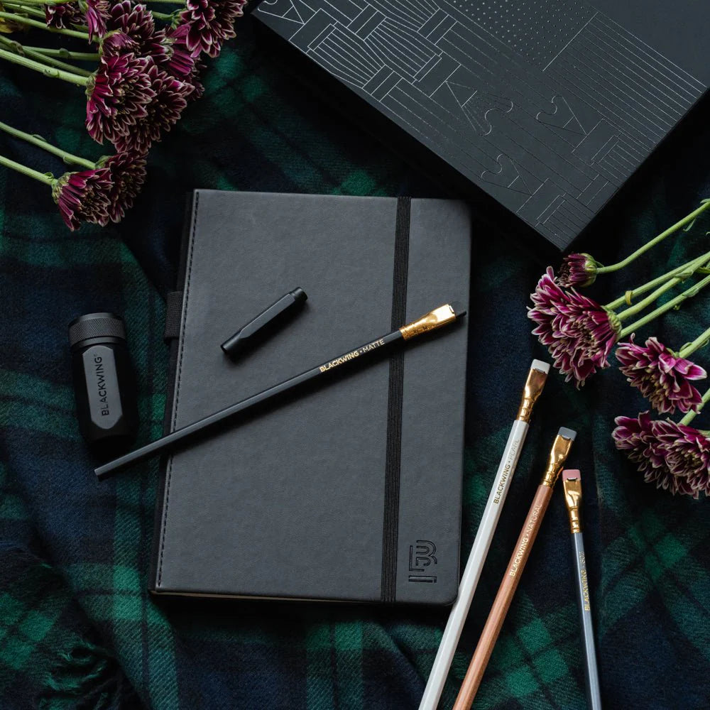 A great way to get started on the Blackwing journey. Give the gift of high-quality Blackwing pencils, paper & accessories — all in one box set.
Includes a Medium Black A5 Slate Notebook, each of our core pencils (602, Matte, Pearl, Natural), One-Step Long Point Sharpener, and Point Guard -- all packaged in a box set.