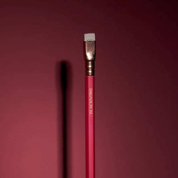 This colorway has a matte red finish, copper imprint, copper ferrule, and light gray eraser. It features a “SOFT” pencil graphite indicator stamp on the barrel. Not to be confused with our red core pencils, this is a graphite pencil with a red barrel. This pencil is ideal for musicians, woodworkers, and anyone who prefers a soft, dark graphite line. The Blackwing Matte is the softest of the four core Blackwing models.
Blackwing Matte pencils come in a 12-pack gift box that also doubles as a pencil cup. The