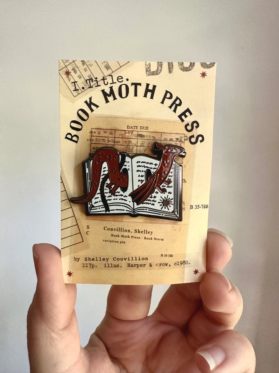 These pins are a lovely, small and cute piece to show off on your clothes, book bags, or wherever you show off your pins!
1.75 inches across, black metal lapel pin with "hard" enamel colors. Black rubber clasps. Packaged in a small plastic bag with a card backing.
"Are your customers book hoarders? No one loves a good horde like a dragon. And I love a good pun, so I combined the two into this Book Wyrm design! Wyrm is the old English word for dragon."