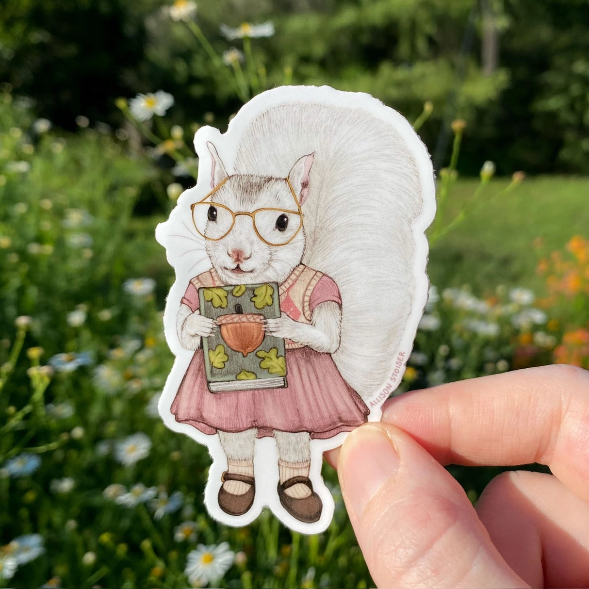 This white squirrel is so happy that the used bookstore had the title she was looking for. Even better: it's a signed first edition!
This die-cut gloss vinyl sticker is durable, weatherproof, and perfect for water bottles, notebooks, laptops, bikes, and all sorts of other surfaces! Make sure to clean and dry the surface thoroughly before applying.