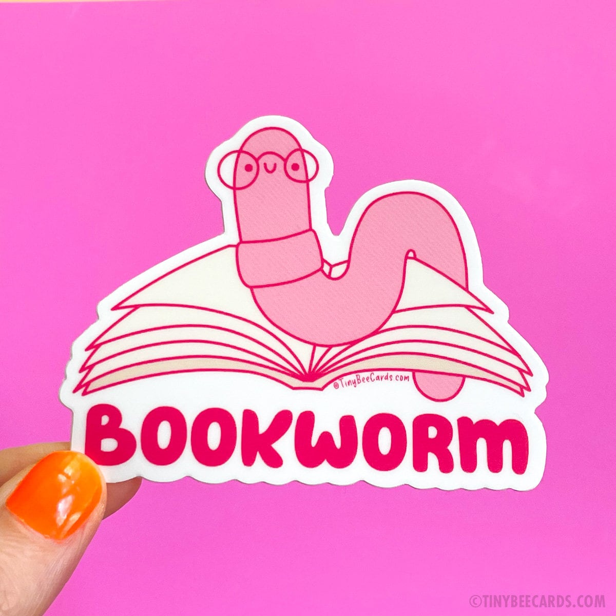 The bookworm is a truly unique creature. This cute little worm spends its days burrowing through the pages of many books and with its tiny glasses it wiggles its way through the literary landscape, reading tales of adventure, love, and knowledge. It immerses itself in the tapestry of stories, traveling through realms of imagination and finds joy in the depths of literature. Celebrate reading with this cute little wormie if that sounds like you too! Design features a hand drawn worm reading a book with the w