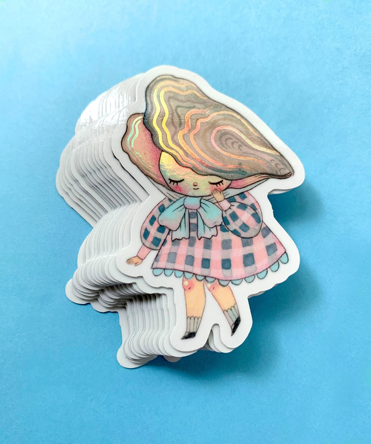 "Pearl" Vinyl Sticker made from Hannakin illustration with subtle holographic accents (on the face and oyster shell) with shiny gloss finish.
Made from a durable waterproof vinyl with a matte laminate that protects it from scratching, rain and sunlight.