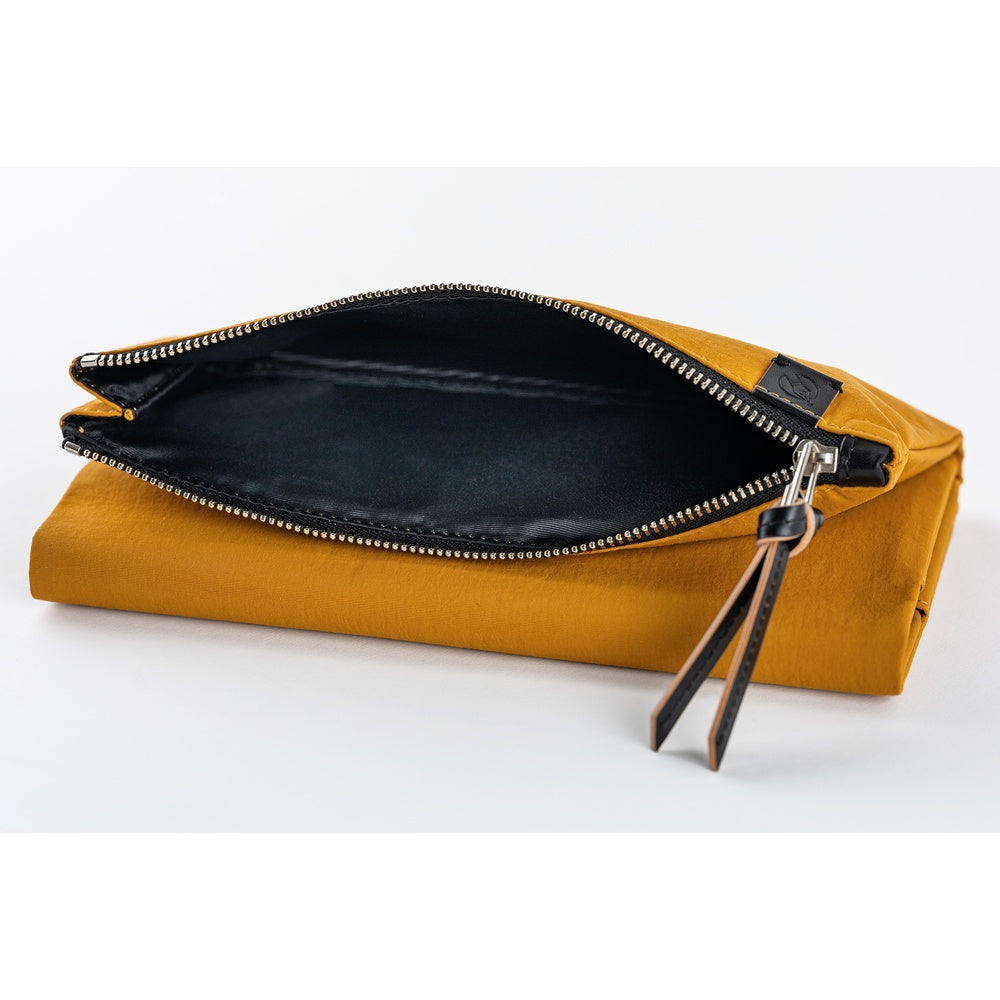 The inside of the pocket is lined with black fabric, creating a striking contrast with the mustard exterior.