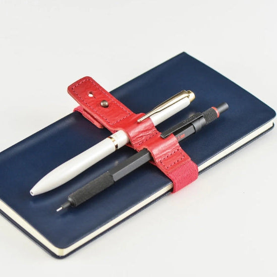 Handy for keeping your book shut in your bag, this bookband is made with an elastic band adorned with the Hobonichi “Hobo” logo. There are two different holes to fit the clasp so you can still use it if your book becomes thicker.
Included in the bookband are slots to store two pens, and the bands come in six colors. (Classic uses natural leather and will grow darker over continued use.)