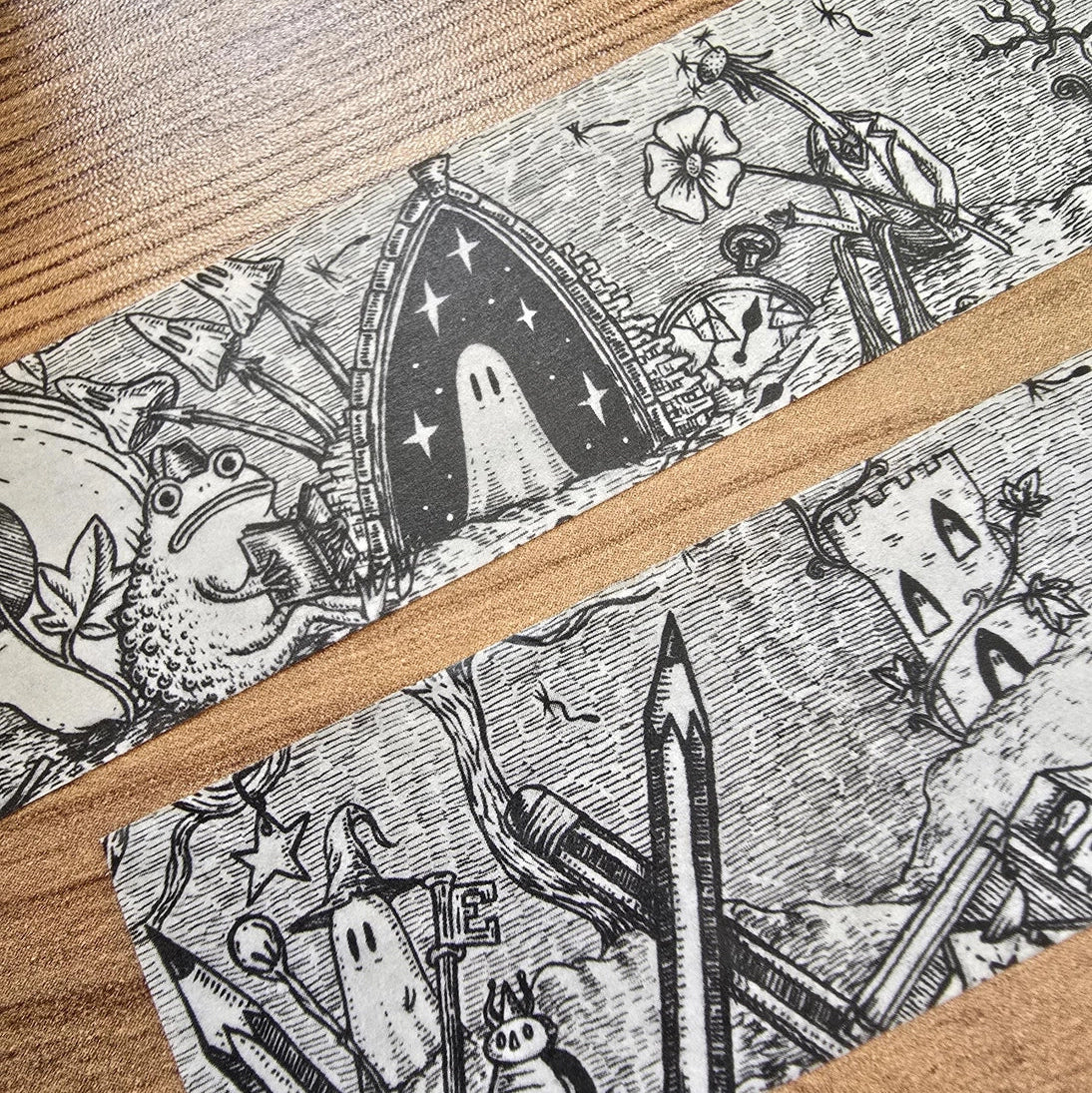 A unique and infinitely repeating fantasy landscape of melancholy oddities and curious characters, from original hand-drawn ink artwork by Jon Turner, recreated with incredible detail at miniature size in this washi tape that invites you to find new tiny details with every viewing.
This is a special extra-wide washi tape, 30mm high which really brings out all the tiny details. perfect for creating a decorative border when journalling, or for packing parcels with surreal style. 10m long.
