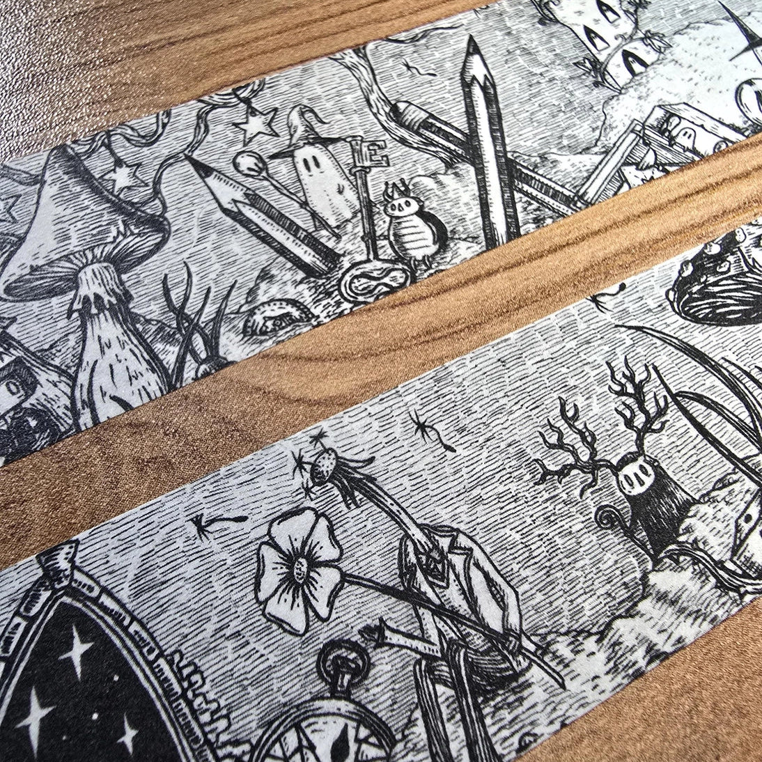 A unique and infinitely repeating fantasy landscape of melancholy oddities and curious characters, from original hand-drawn ink artwork by Jon Turner, recreated with incredible detail at miniature size in this washi tape that invites you to find new tiny details with every viewing.
This is a special extra-wide washi tape, 30mm high which really brings out all the tiny details. perfect for creating a decorative border when journalling, or for packing parcels with surreal style. 10m long.