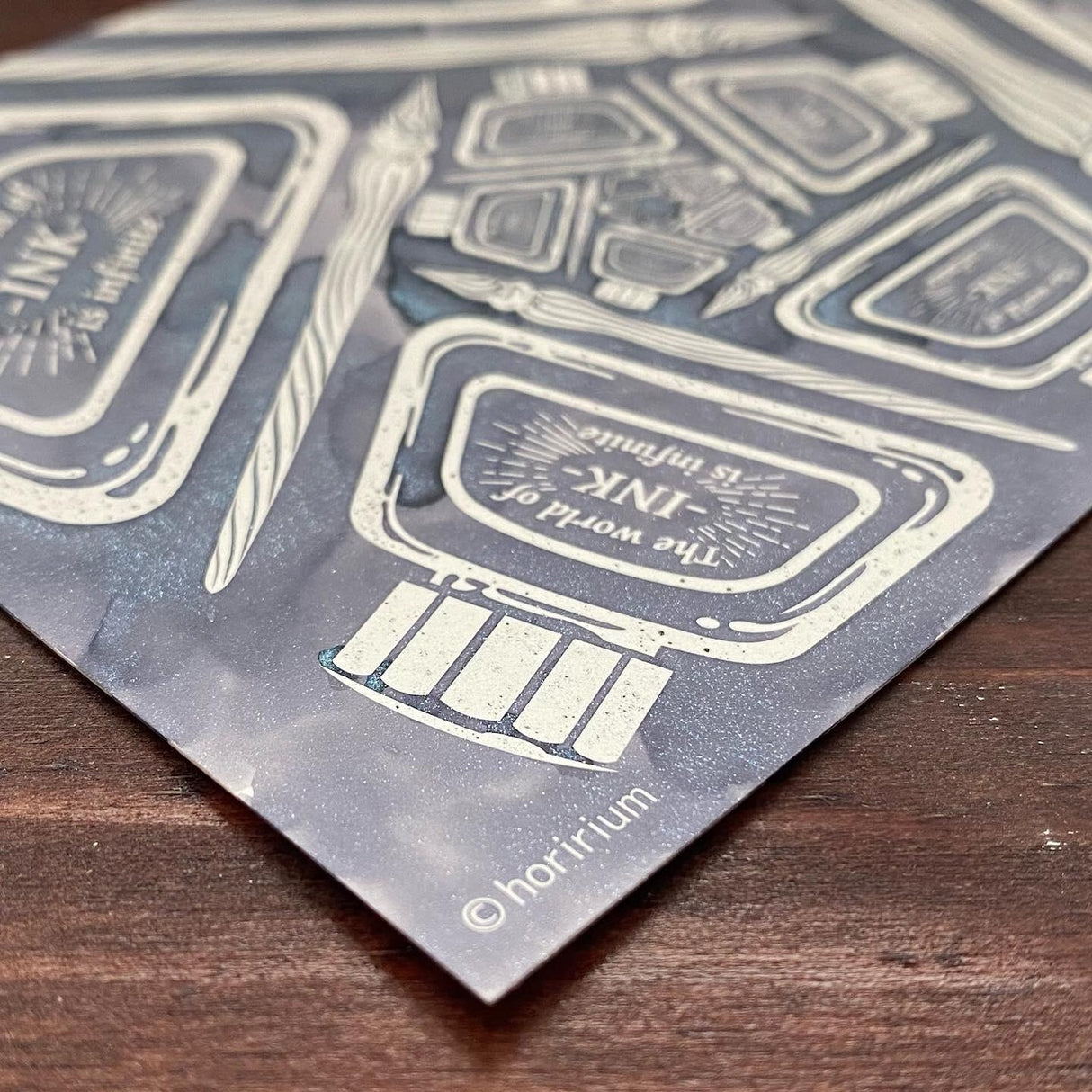 Designed by Horirium, who is familiar to stationery fans as a designer of decorative manuscript paper, drew an infinite pattern of an ink swamp.
These are best used with water-based inks in general, but dye inks are more suitable than pigment inks (they are easier to refresh cleanly). In rare cases, some inks are difficult to reject, so please try them out before using them.
Includes:
Body size: 100x148mm (postcard size)
Material: Paper (1 pack of 5 sheets)