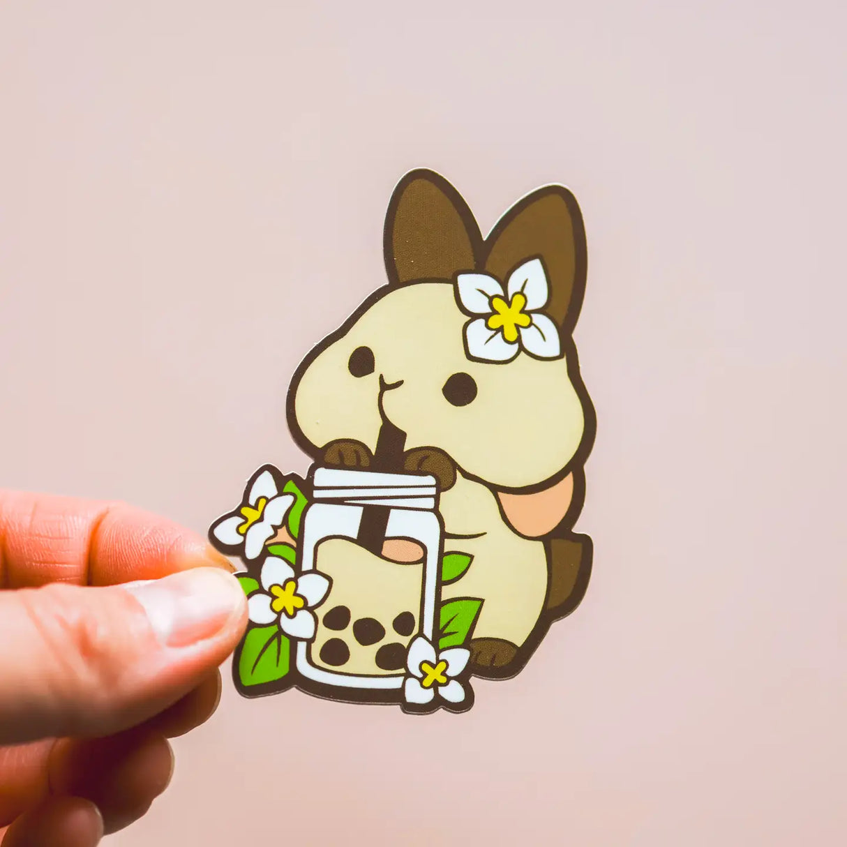 Cartoon character holding a glass of bubble tea with flowers on a beige background