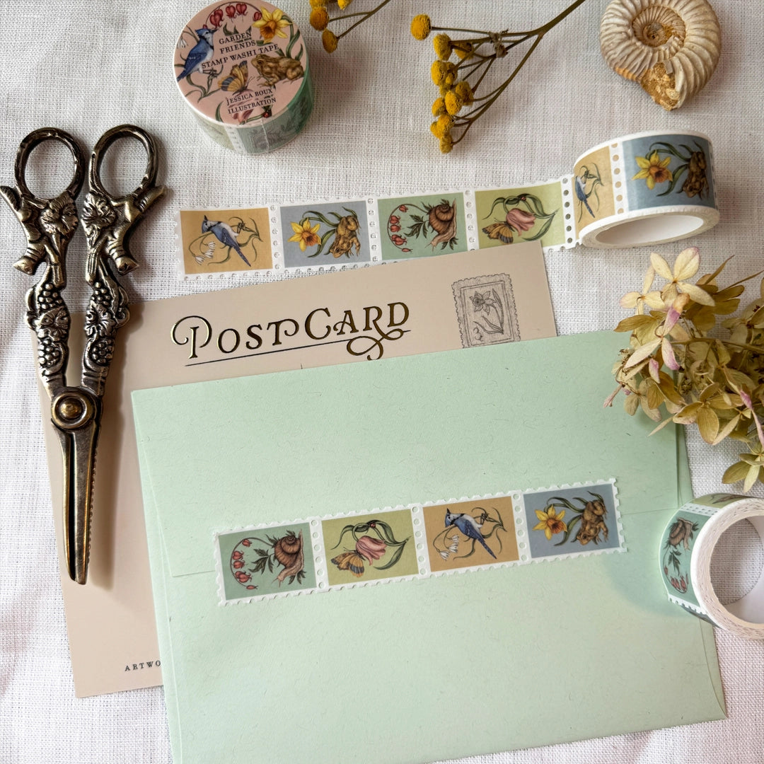 Washi tape featuring garden friends, including a blue jay with a snowflake flower, a toad with a daffodil, a moth and ladybug with a tulip, and a snail with a bleeding heart plant. Illustrated by Jessica Roux.
Each tape is 25mm wide. Individual stamps feature perforation for tearing or cutting. Matte finish perfect for scrapbooking, bullet journaling, and more.
Please note, these are decorative and have no postage value.
Each tape is shrink wrapped and has a sticker label.