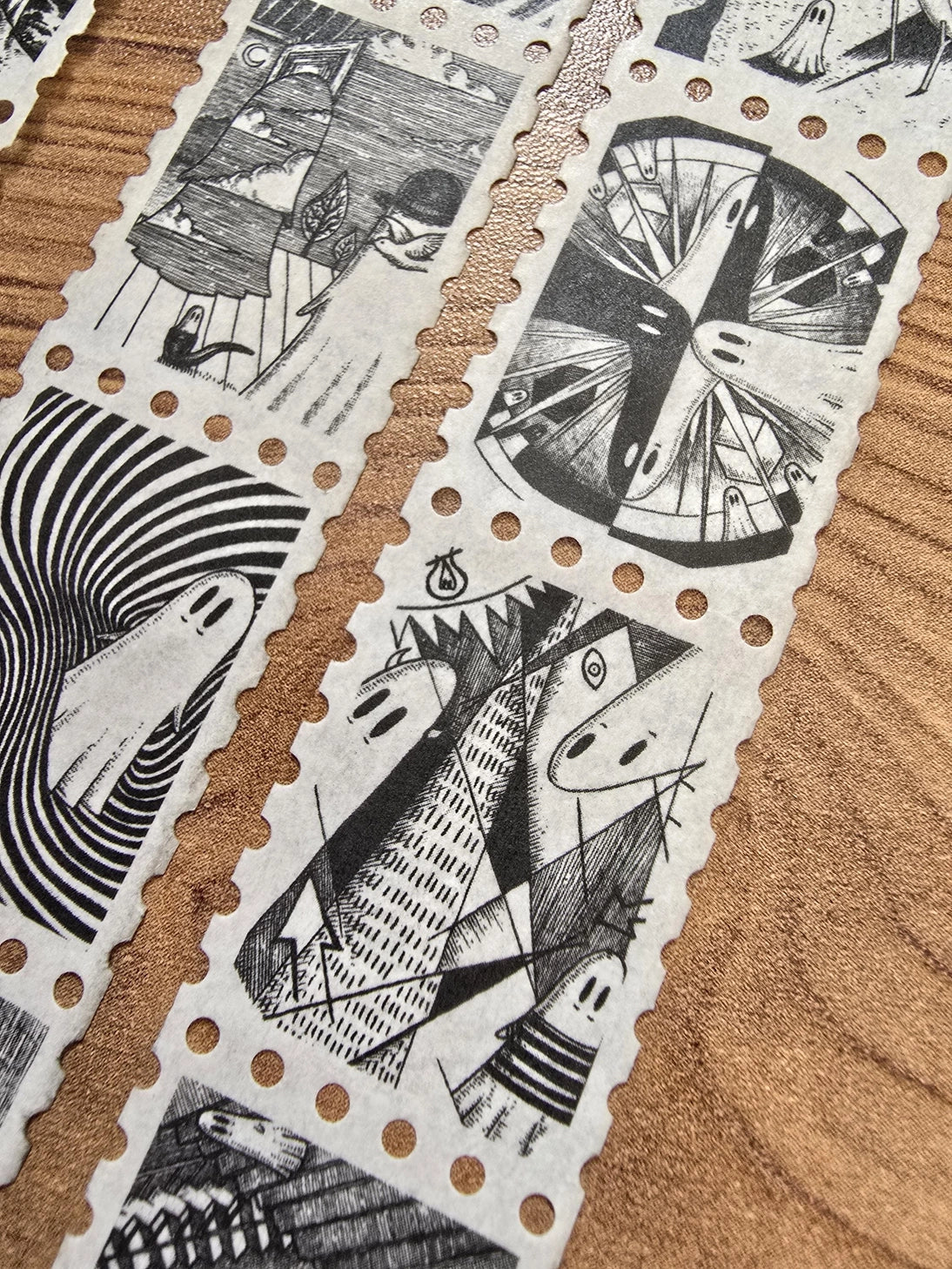 The second of two tapes from the Creative Spirits series by Jon Turner, little ghosties taking you on an eclectic tour of art history. This roll features ghosts inspired by Bridget Riley, Rene Magritte, Hilma Af Klimt, Georgia O'Keeffe, Salvador Dali, Paul Cezanne, Pablo Picasso, Georges Seurat, MC Escher, and Jean-Michel Basquiat.
Perforated to look like a roll of postage stamps, this washi tape features a repeating pattern of ten designs in portrait format from hand-drawn pen and ink artwork, recreated i