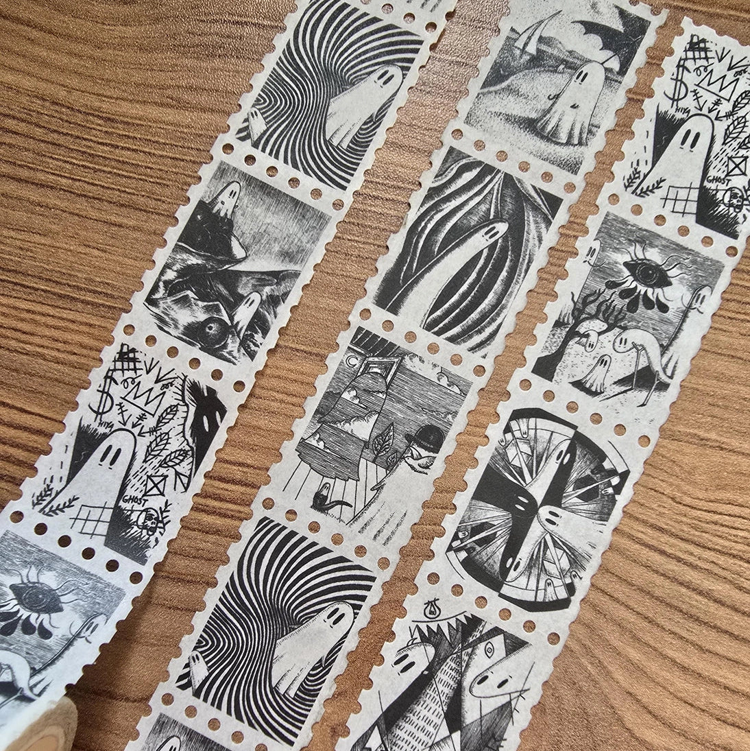 The second of two tapes from the Creative Spirits series by Jon Turner, little ghosties taking you on an eclectic tour of art history. This roll features ghosts inspired by Bridget Riley, Rene Magritte, Hilma Af Klimt, Georgia O'Keeffe, Salvador Dali, Paul Cezanne, Pablo Picasso, Georges Seurat, MC Escher, and Jean-Michel Basquiat.
Perforated to look like a roll of postage stamps, this washi tape features a repeating pattern of ten designs in portrait format from hand-drawn pen and ink artwork, recreated i