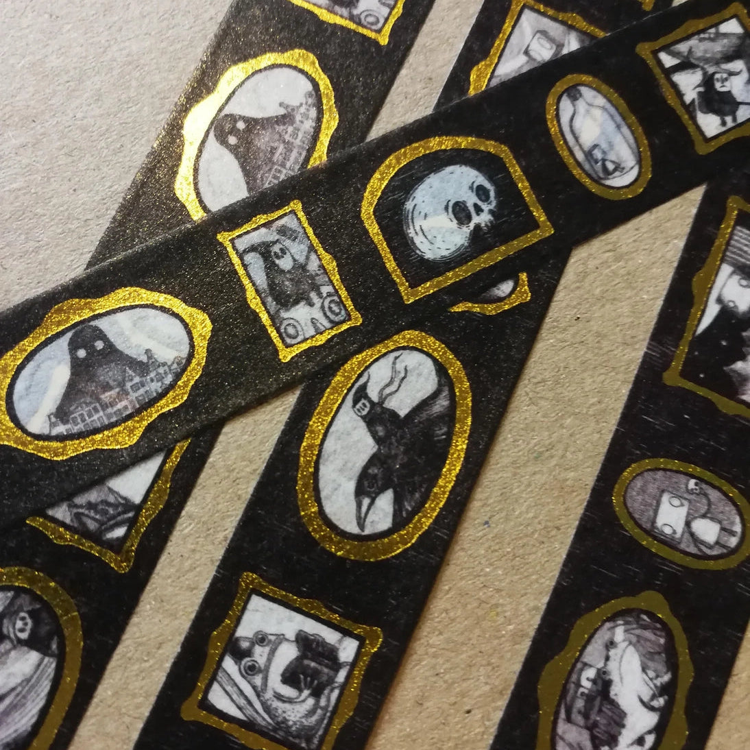 Turn every surface into a tiny gallery with this washi tape featuring tiny Jon Turner artworks in shiny gold frames, an array of little robots, ghosts and other spooky oddities. Perfect for spooky journalling or curious correspondence.
Two designs available, with each tape featuring 16 miniature masterpieces in a repeating pattern. Each roll measures approximately 15mm wide, and the roll is 10m long; they are cello wrapped and decorated with branded stickers on either side.
15mm wide
10m length