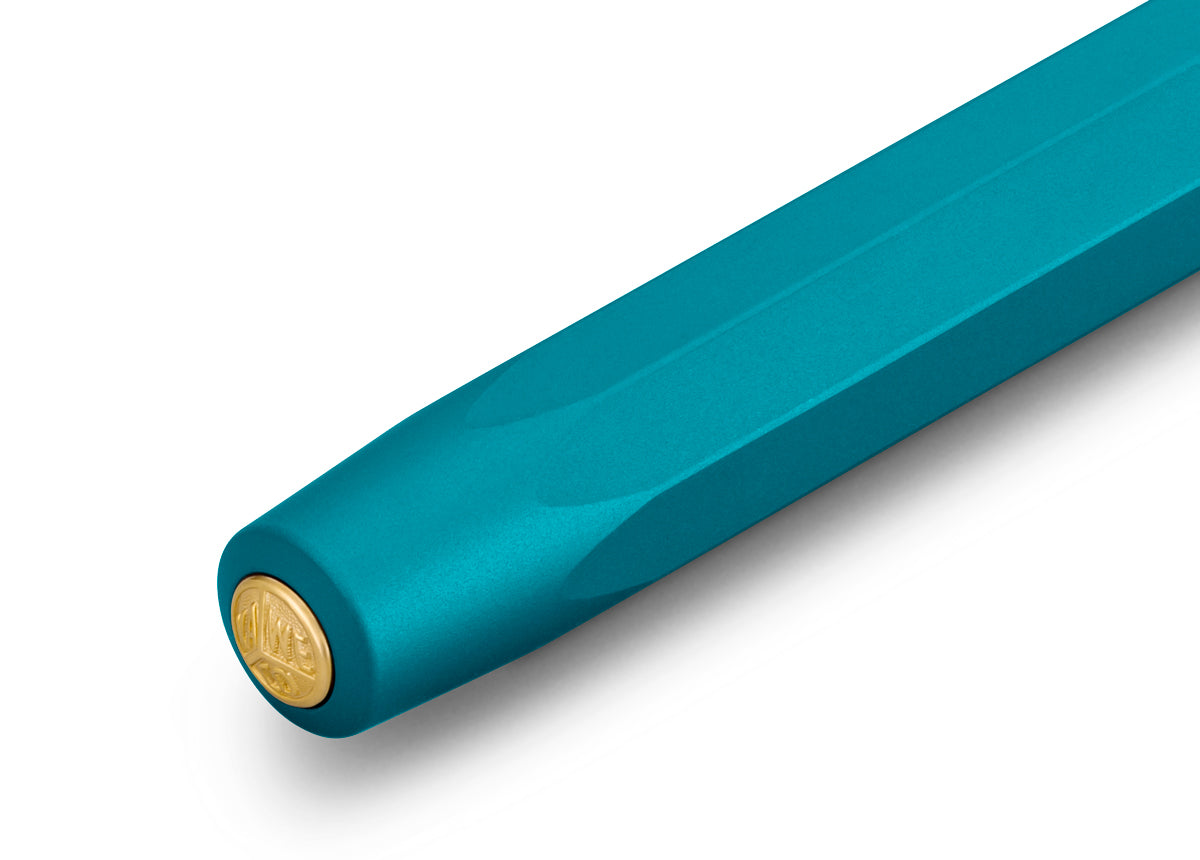 With the new Kaweco Collection variant, you embark on an exotic trip. The inspiration for this magnificent fountain pen has come from the rare blue iguana. Thus, the Kaweco icon shines in a fantastic blue-green anodisation. Especially the silk-matt finish of the surface and the distinctive haptic of the aluminium body create a graceful appearance. The gold-plated elements complete the design perfectly.
In 1911 something remarkable by the name of Kaweco Sport was created. The pocket-sized fountain pen only