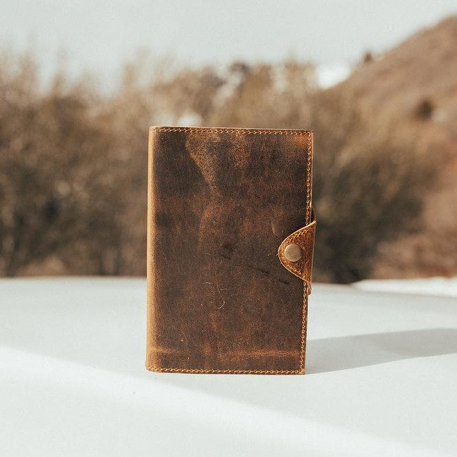 Kodiak Leather Drifter Leather Journal
The Drifter Leather Journal is designed for travelers, writers, and creatives who appreciate quality craftsmanship and timeless style. Made from top-grain leather, this beautifully crafted journal features a secure snap-button closure and handmade artisan paper, making it an ideal gift for adventurers and homebodies alike.
With 210 blank pages and a refillable design, it’s perfect for capturing thoughts, sketches, or travel memories. Measuring 7” x 5” x 2.5”, the Dri