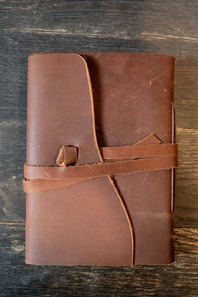 Kodiak Leather Traveler's Journal - Medium
The Kodiak Traveler Journal is the perfect travel companion. Made with durable top grain leather, a leather wrap closure and handmade artisan paper this journal is the ultimate gift item for the world traveler or home-body.
• 110 blank pages
• Made with handmade artisan paper
• Top Grain Leather
• Dimensions: 5" x 7"