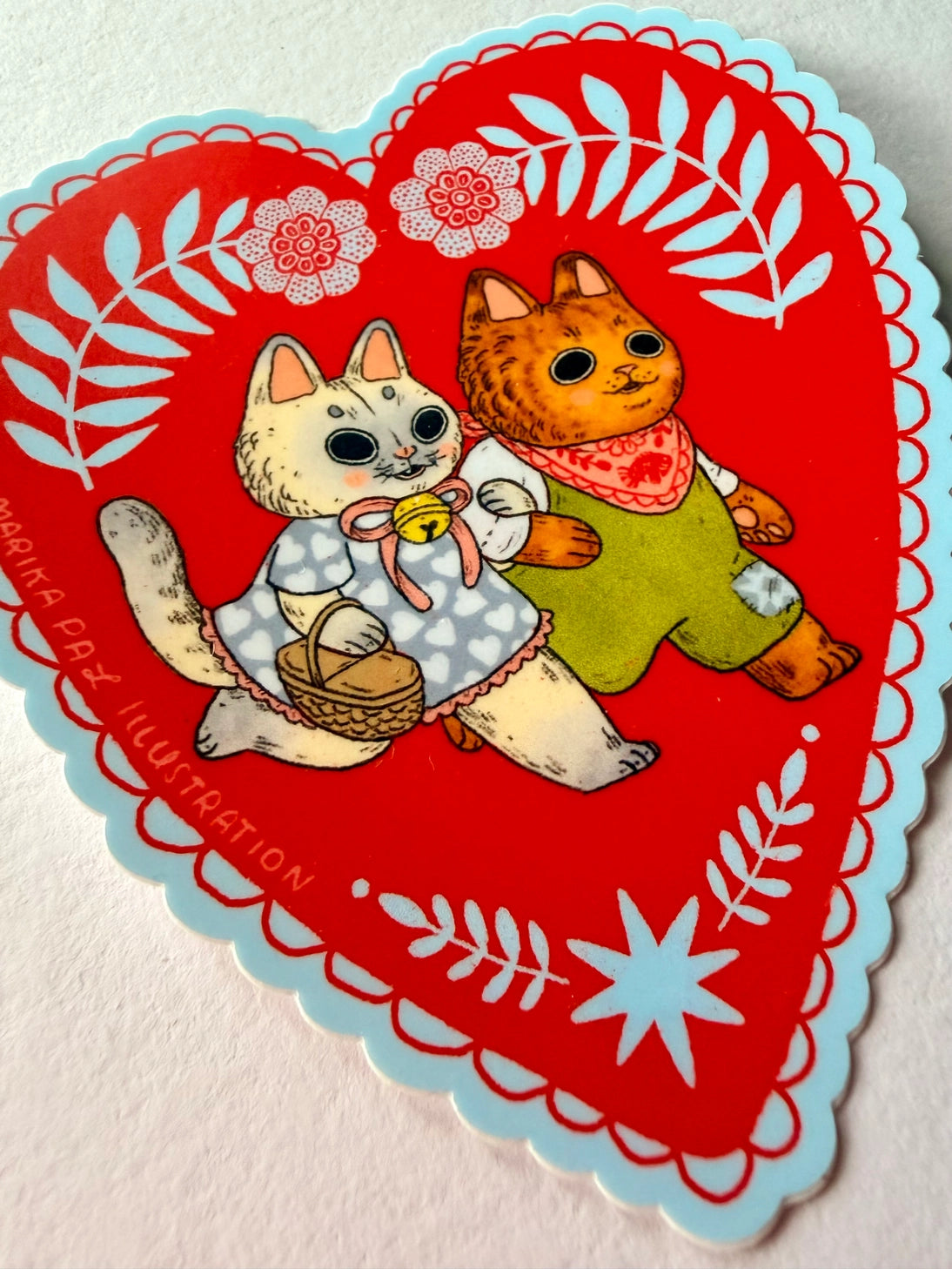 Two cats go for a walk on this folk art inspired sticker.
This vinyl matte sticker is weather and waterproof-stick it on a notebook, bike, or car- it's going to stick around! Heck, throw it on a water bottle and through the dishwasher. This sticker can go anywhere. Sticker measures 3.5" x 4.5" Printed in USA.