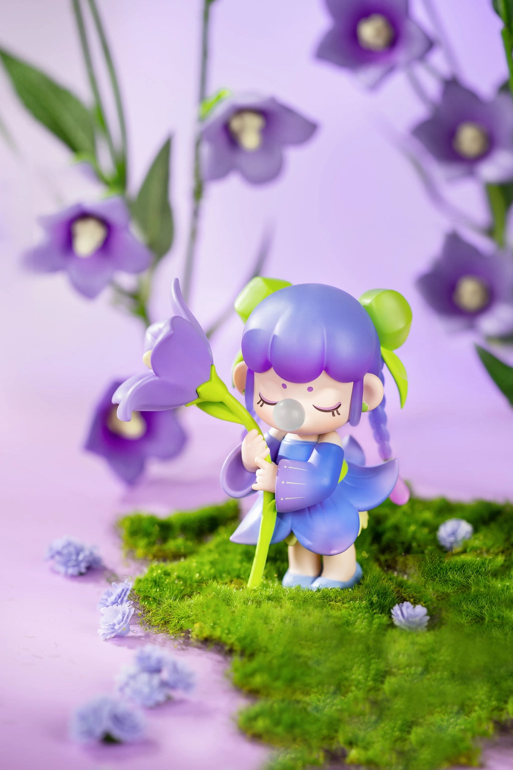 Nanci Flower Stories Figure Dolls Blind Box Animated character with purple hair and outfit holding a flower among purple flowers on a grassy patch.