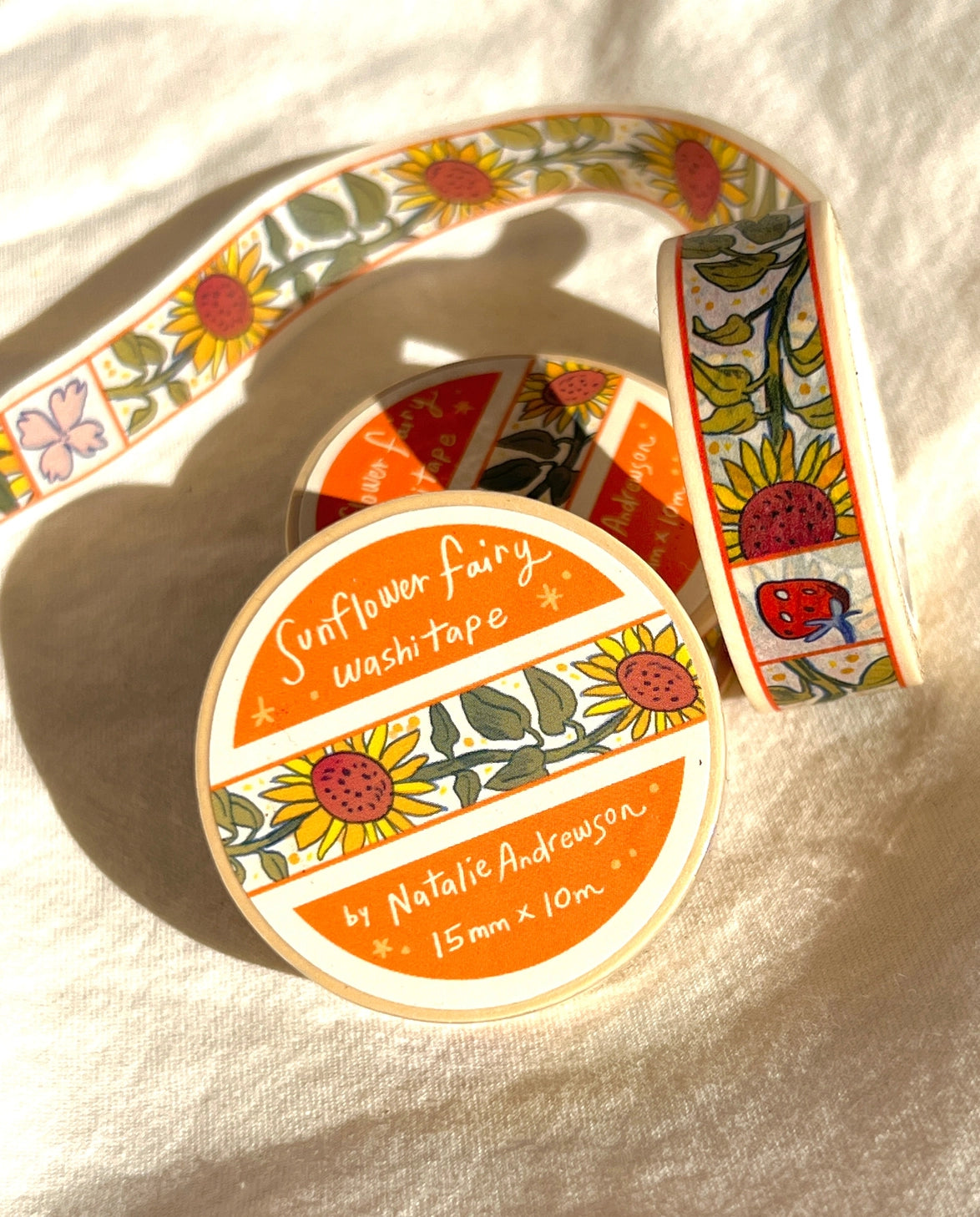 This washi tape features little sunflowers dancing one by one separated by flowers and strawberries. This tape design is taken from my Sunflower Fairy print's decorative borders.
This roll is 15mm wide x 10m of paper tape. Washi tape is super durable and flexible. It tears easily and can be safely applied to a variety of surfaces; it doesn’t leave a sticky residue behind, making it especially ideal for stationery and hanging prints temporarily.