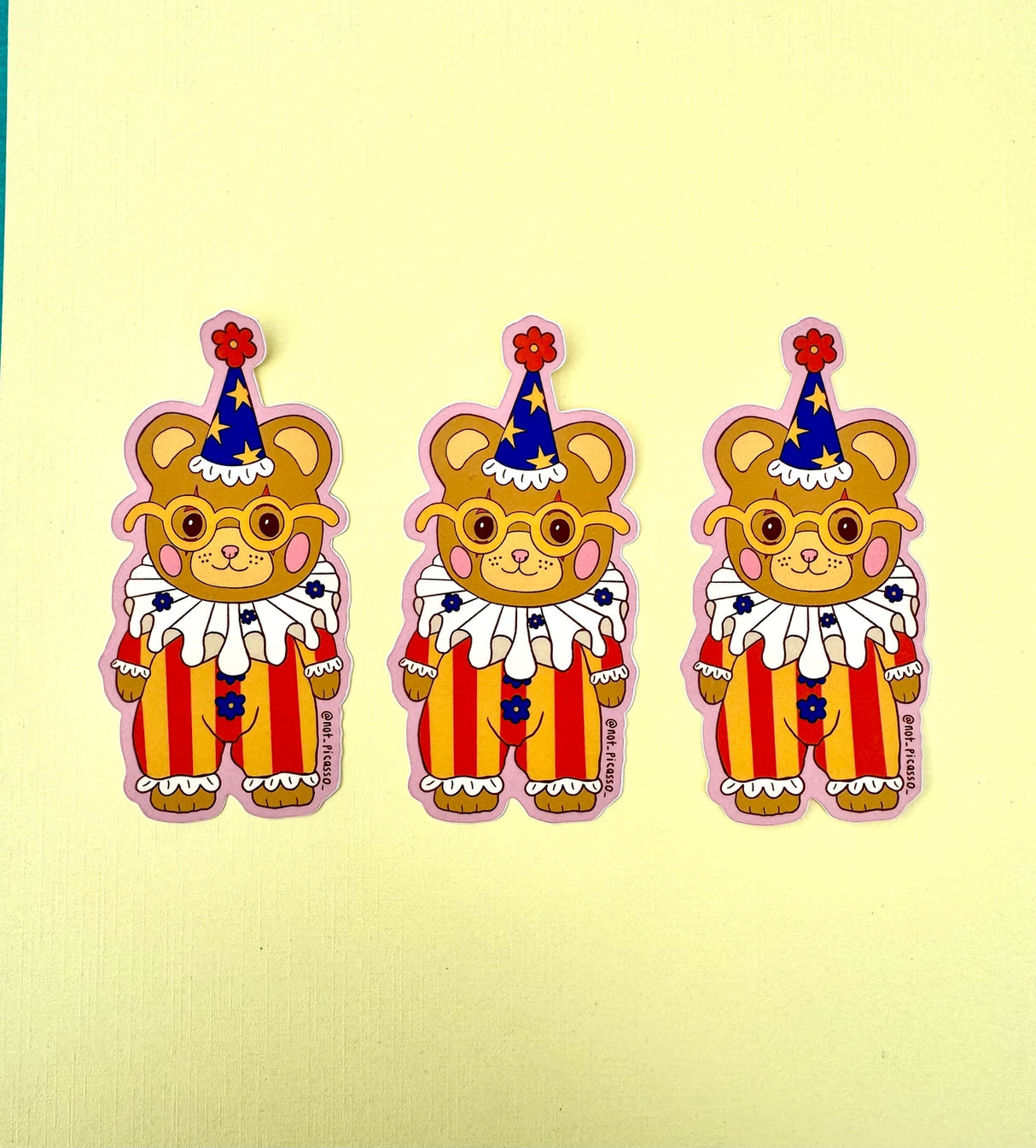 These adorable stickers feature a cute little bear in a clown suit.
These matte vinyl stickers feature an original design and are water, weather, and scratch proof. Perfect for putting on water bottles, computers or just about anywhere else.