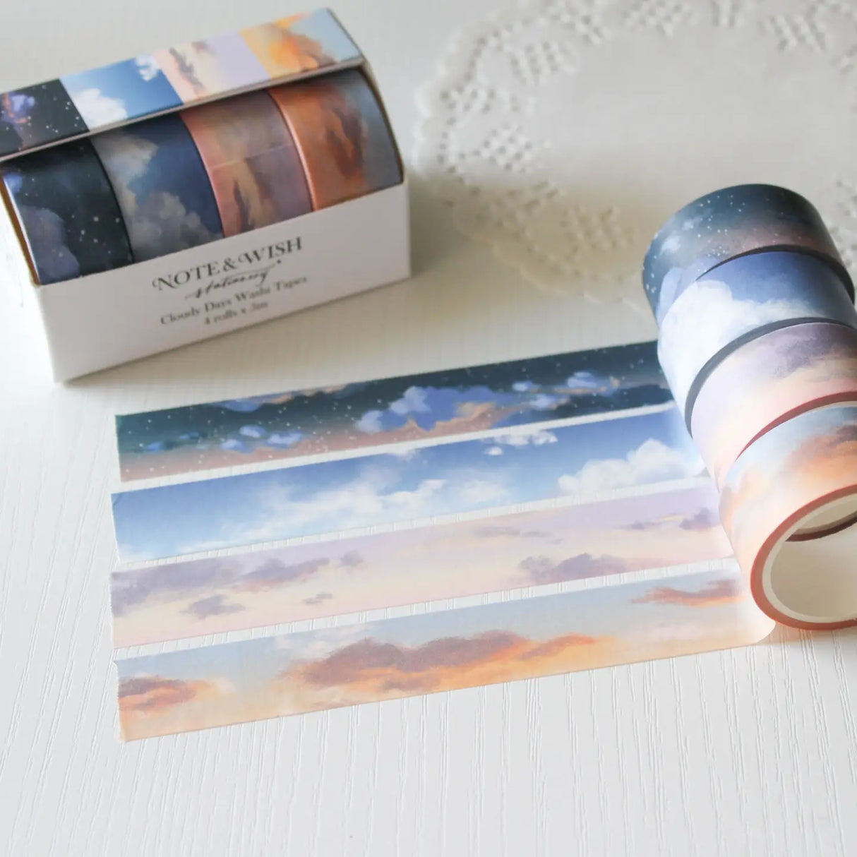 This washi tape box set is designed for journalers, sky gazers, and stationery lovers who find beauty in the ever-changing colours of the sky. Featuring four digitally drawn skyscape designs by Rebecca, each roll captures a different season, from soft spring sunrises to moody winter twilights, all packaged in a beautiful presentation box.
The four designs included:
* Cloudy Days Spring — soft purple and peach sunrise tones
* Cloudy Days Summer — sky blue with drifting white clouds 