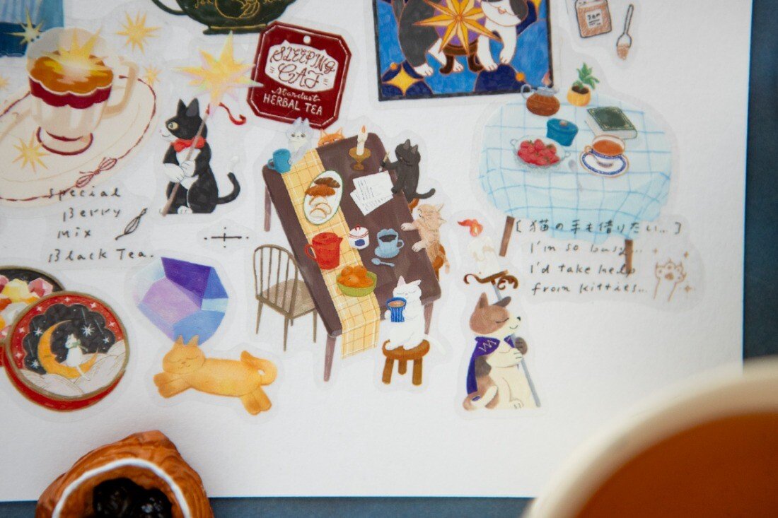 Welcome to the Tea Room! This kiss-cut PET Tape features a relaxing teahouse filled with cats and other furry friends. It adds the perfect touch of warmth to your journal pages with hints of golden brown and dark blue as conversations continue until midnight.