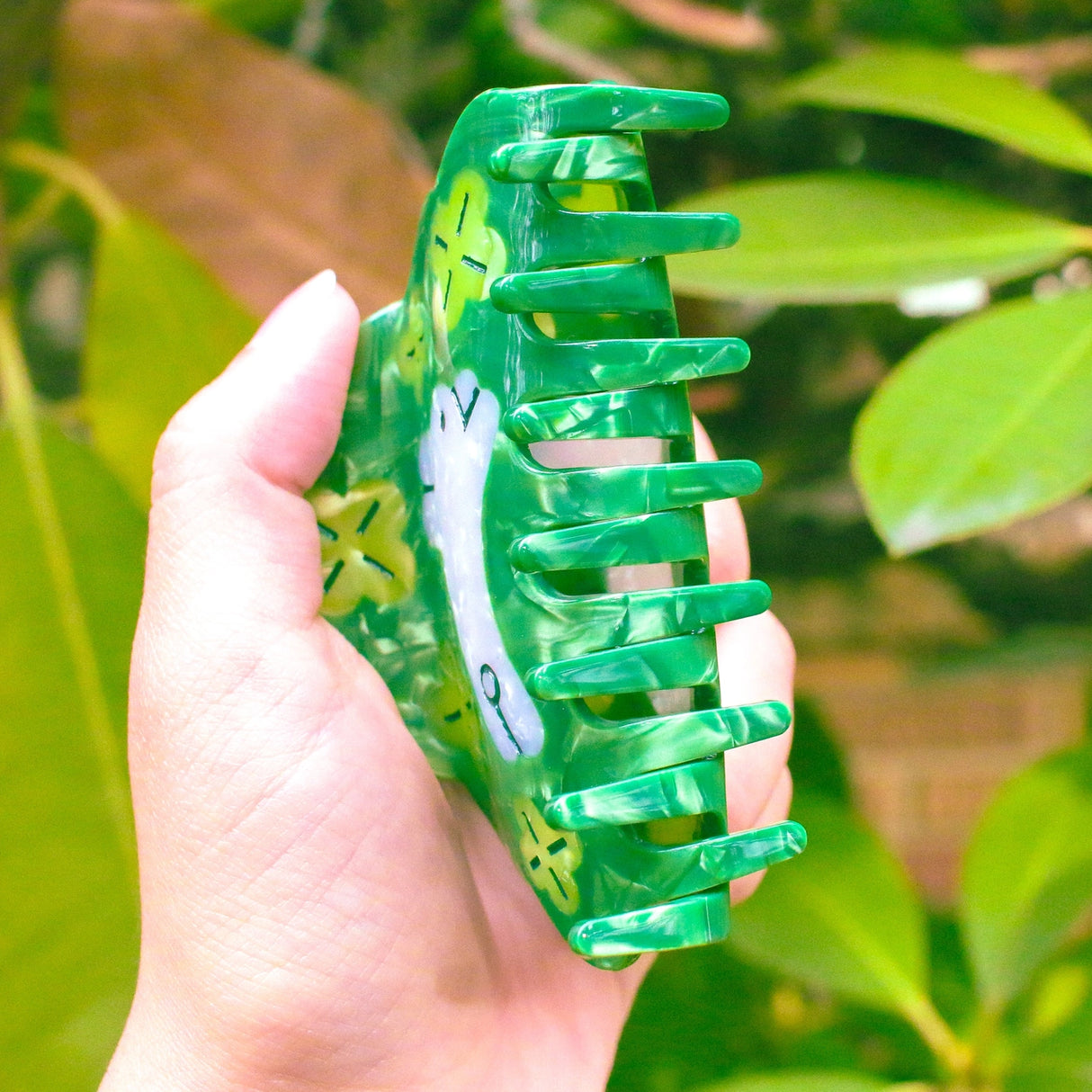 Clover Hair Claw featuring a little rabbit leaping through a field of clover.
Made of acetate, 3.5 inches long. 