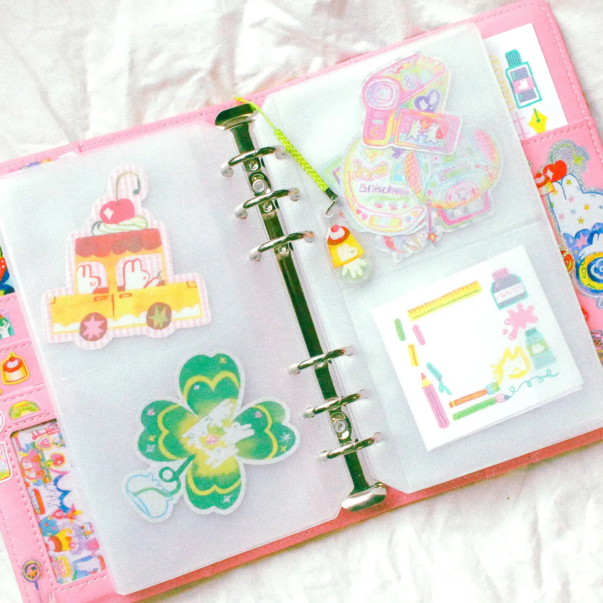 This is a A6 six ring binder that measures 14 cm x 19 cm when closed! It includes interior pockets for extra storage and a hole on the spine for charms.
This binder is great for storing stickers, sticker packs, note cards, photo cards, pet tape loops, ephemera and small sticker sheets. They can also be filled with paper and used as a notebook or journal.