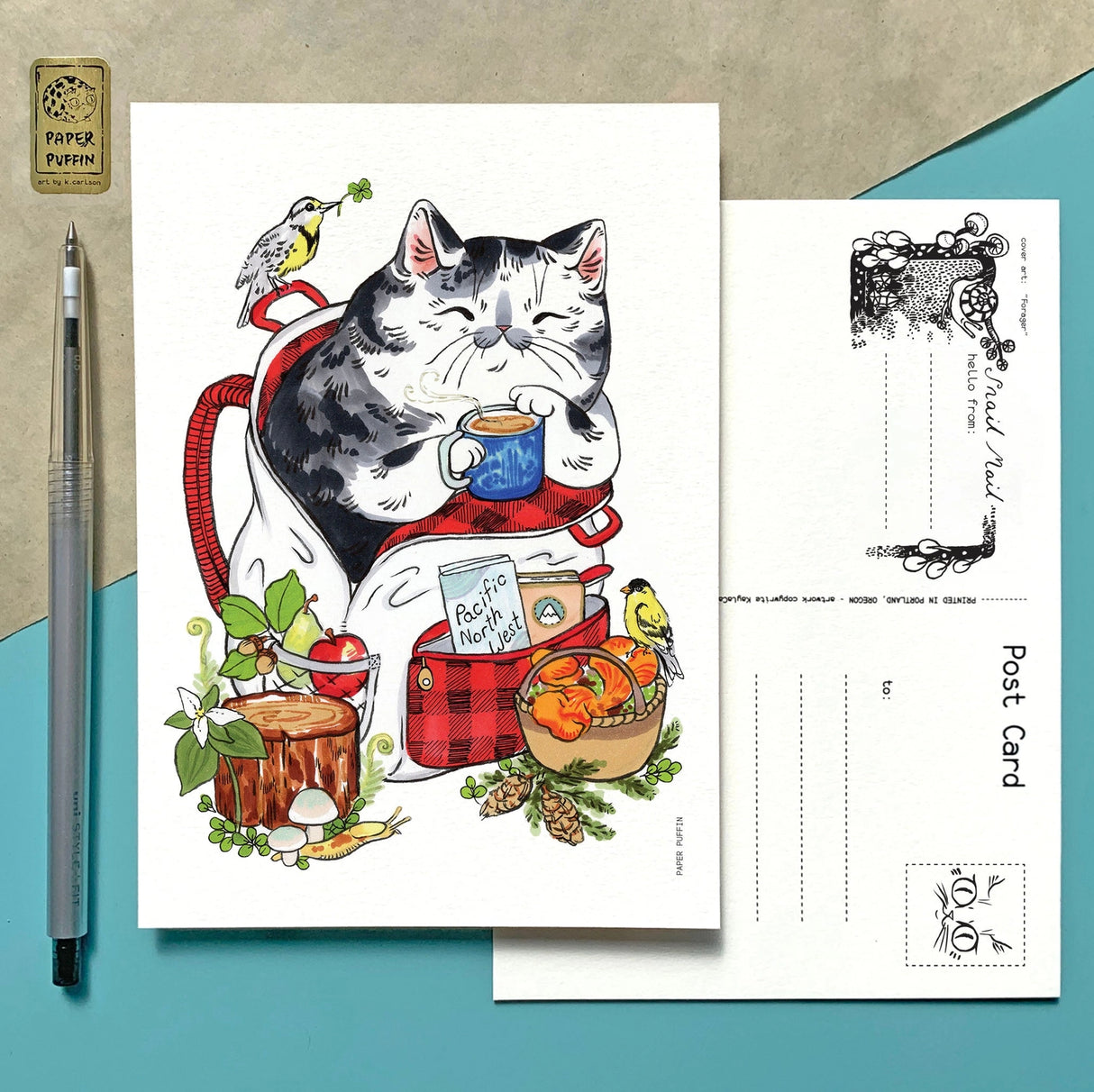 A happy camping cat, there are bits representing Oregon and Washington such as Meadowlark and Goldfinch birds, the iconic banana slug, trillium flowers and chanterelles, Douglas Fir... can you spot them all?
+ size: 4.25 x 6” standard size, regular postage stamp
+ printed on a ‘toothy’ rag off white color card stock paper
+ FSC 100% recycled environmentally friendly paper
+ created and printed in Portland, OR
All work and photos ©PAPER PUFFIN Art by K.CARLSON