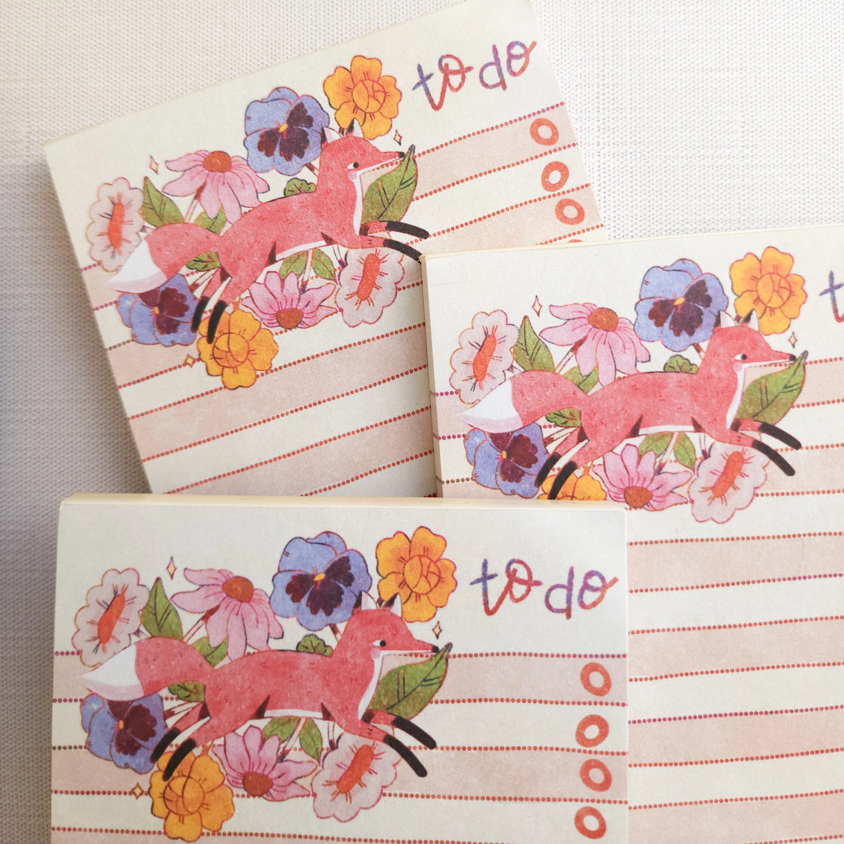 In a quiet clearing of Wildflower Woods, a fox moves through blooming flowers, petals lifting gently as he passes beneath open sky. This notepad brings that playful, woodland moment to your desk, making everyday lists feel a little more inviting.
Designed to be practical without feeling busy, this notepad offers a simple, cheerful way to keep track of daily to-do lists and planning.