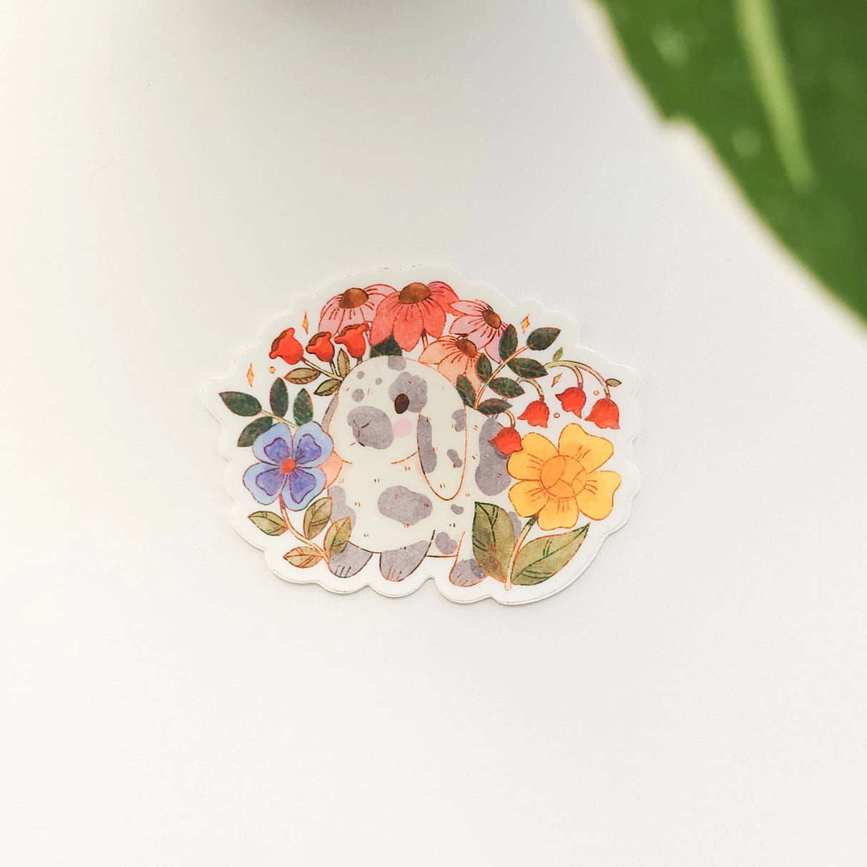 A charming dachshund planter rests among leafy greenery, a thriving cheese plant growing from its back like a small piece of playful décor. This vinyl sticker captures that cozy, plant-filled still life, adding a touch of warmth and whimsy to your everyday essentials.
Made from durable, waterproof vinyl, this sticker is designed to hold up wherever you place it—whether that’s a water bottle, laptop, or journal you reach for daily.