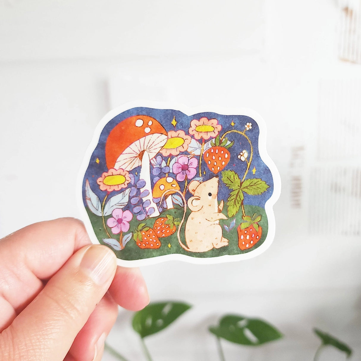 A cheerful little mouse pauses along a sunny garden path in Wildflower Woods, holding a ripe strawberry close before continuing on its way. This vinyl sticker captures that small, joyful moment, celebrating the simple pleasures tucked into everyday life.
Made from durable, waterproof vinyl, this sticker is designed to hold up wherever you place it—whether that’s a water bottle, laptop, or journal you reach for daily.