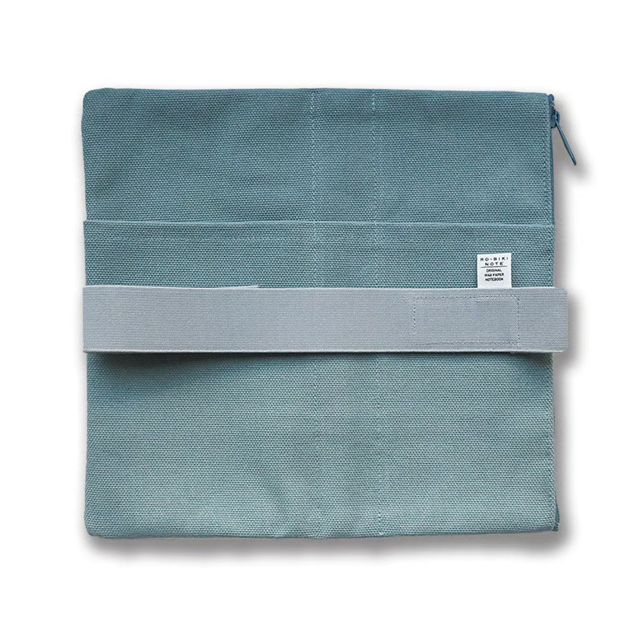 Made of cotton that feels good to the touch, this is RO-BIKI NOTE CANVAS COVER vintage blue. A zippered pocket on the side is useful for storing stationery that tends to be loose. It has a simple design that does not stand out when carrying. When closed, it feels neat and sizable. The surface of the cover has three pockets of different sizes, so you can enjoy multiple storage options.
With a connecting band, you can sandwich the Basic size and the passport size at the same time.