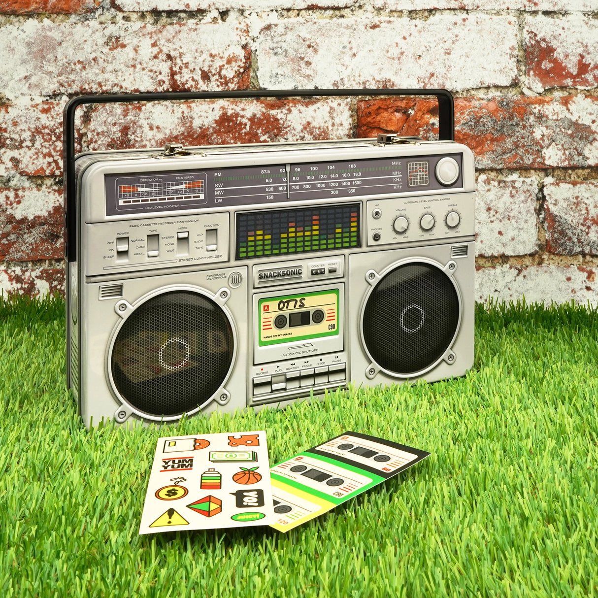 Cool kids bring their own lunch. The coolest kids carry lunch like it's 1989 and you're a street-wise New-York Hip-Hop kid. A classic tin lunch box disguised as a super cool retro ghetto blaster. Big enough for a good size packed lunch and fun enough for both kids and adults. Experience the nostalgia of the 80s. Keep your food fresh and organized. This is not just a lunch box, this is a statement of intent!
Durable and built to last the rigours of school.
Animated lenticular graphic equalizer.
Metal