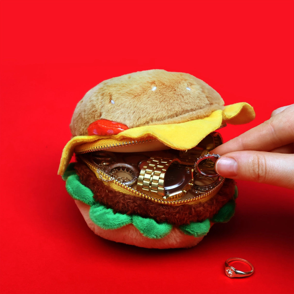 SUCK UK Plush Pouch - Hamburger
Plush burger shaped case with gold zip. Store your belongings amongst the salad and the melted cheese. Yum!
Juicy, tasty, sweet and sour. And very cute. Stuff your stuff into something soft, and squishy. Delicious looking plush zip pouches look like foodie treats but instead of calories, they hold your everyday essentials. From cheesy slices to sickly treats, each pouch is designed to be irresistible and practical. Perfect for pens, cables, cosmetics, or whatever bits and b