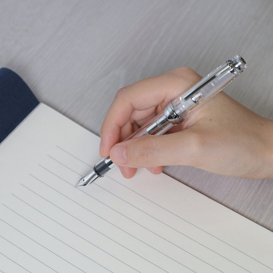 The Sailor Pro Gear Transparent fountain pen has a clear barrel with silver trim. The pen has been fitted with a 14k solid gold nib that has been rhodium plated to match.
Pro Gear Slim size
14k gold nib with Rhodium plating
Includes 2 proprietary black ink cartridge and 1 converter