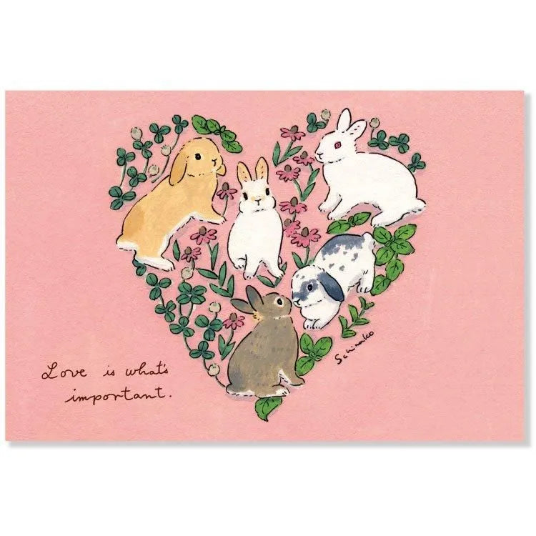Share your love with this adorable postcard by Schinako Moriyama! This postcard features bunnies in the shape of a heart with the message "Love is What's Important".
4in x 5.8in