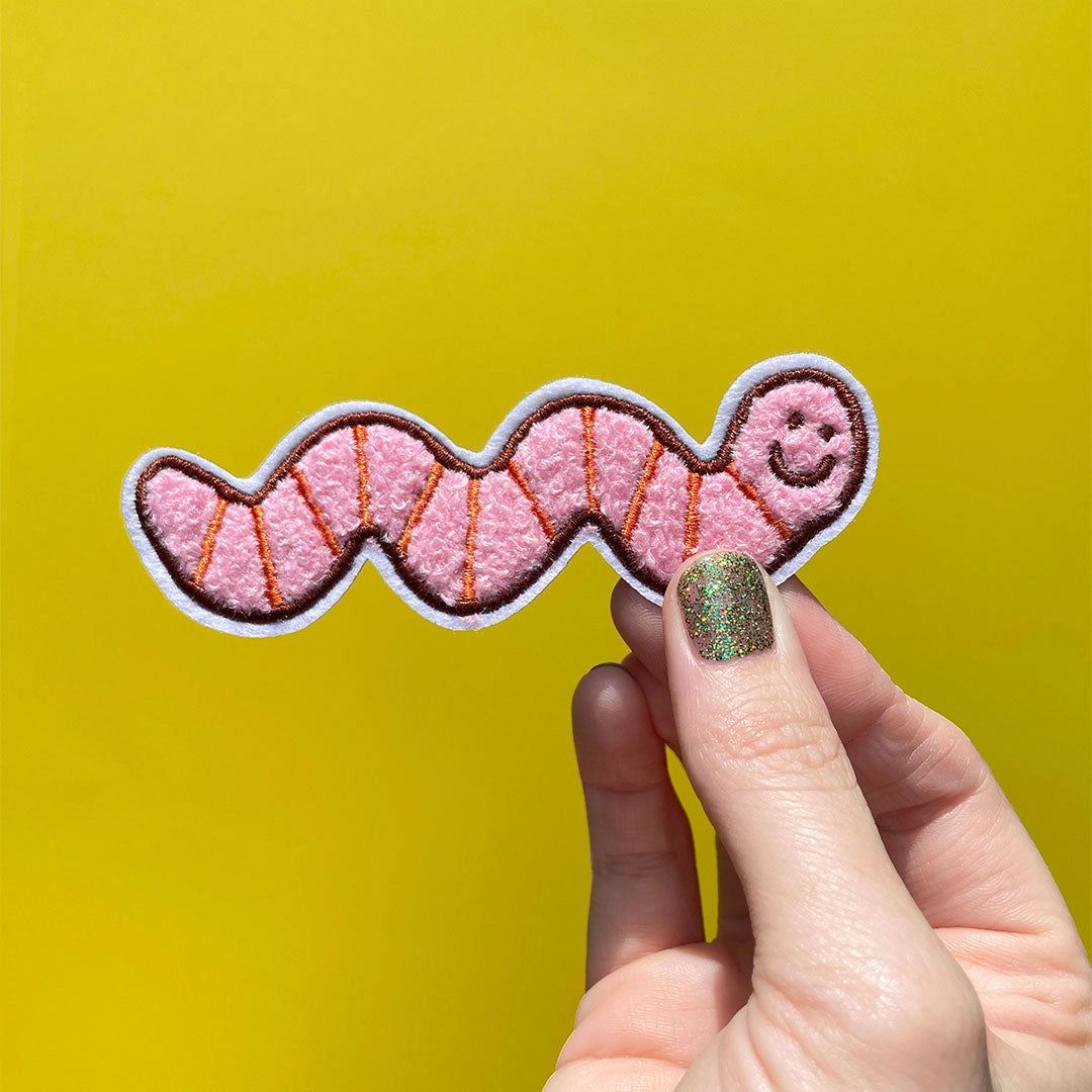 Made from the softest chenille this side of the compost heap, this fuzzy patch has more wiggle than a caffeinated earthworm on a hot sidewalk!
Chenille embroidered with white felt border
Iron on backing
4.15" x 1.31"
Packaged in a cellophane hanging bag
Recycled kraft paper backing card
Application instructions are included on the back side of packaging
Designed in Knoxville, TN, produced in China