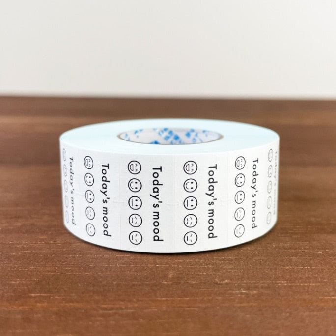 Stamp Marche Planner Label Sticker Roll - Today's Mood Roll of tape with printed text and symbols on a wooden surface