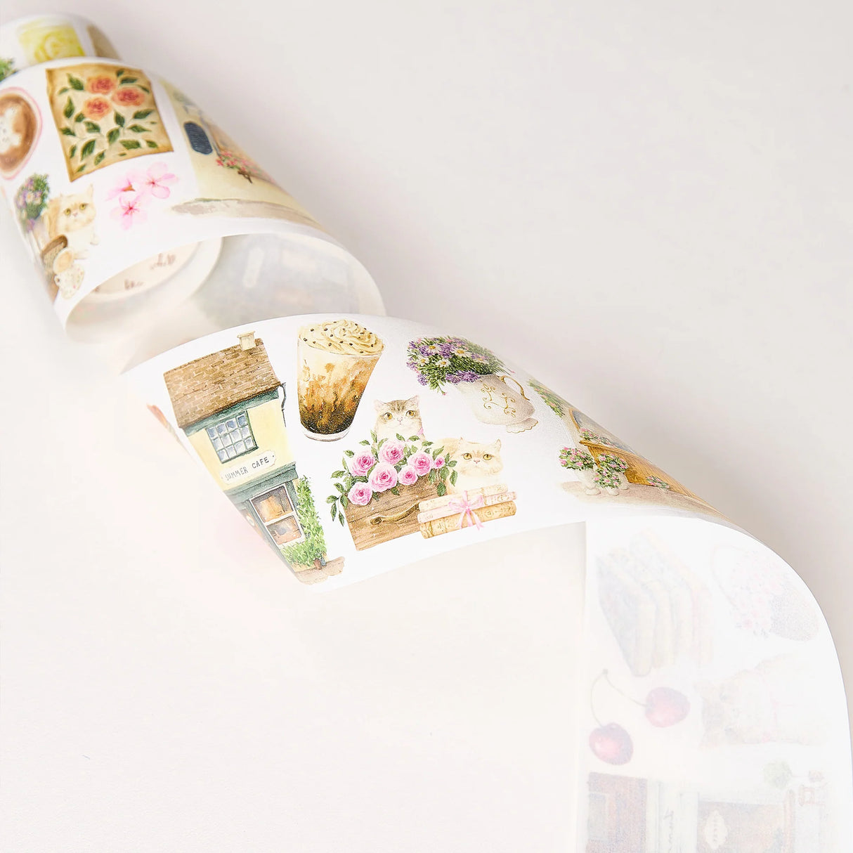 Step into a world where nature and comfort collide. Our Summer Café Wide Tape transforms your stationery into a bustling garden bistro, teeming with life, blooming flowers, and the true owners of the cafe: the cats.
This whimsical design weaves together the architecture of charming coffee shops with the wild beauty of summer florals. Nestled among the potted plants and open doors, you’ll find hand-painted cats exploring, sleeping, and playing. 