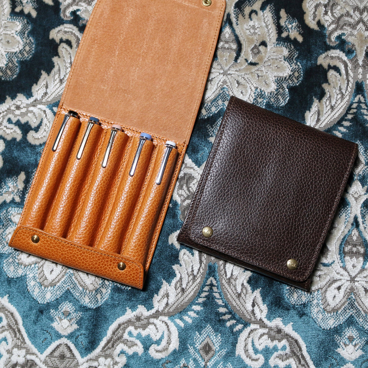 This case for fountain pens can hold five pens individually.
Lined with pig suede for a luxurious look and feel, your precious pens will be well protected and carried.
The buttons are original, made of solid brass and stamped with T.S.L.
SIZE : L13cm × H15cm
COLOR : Camel / Brown / Black
MATERIAL : Cow leather
Leather Products:
The leather used in this product is natural leather.
We do not use scratches that lead to tears or rips, but we use scratches and wrinkles that are originally
