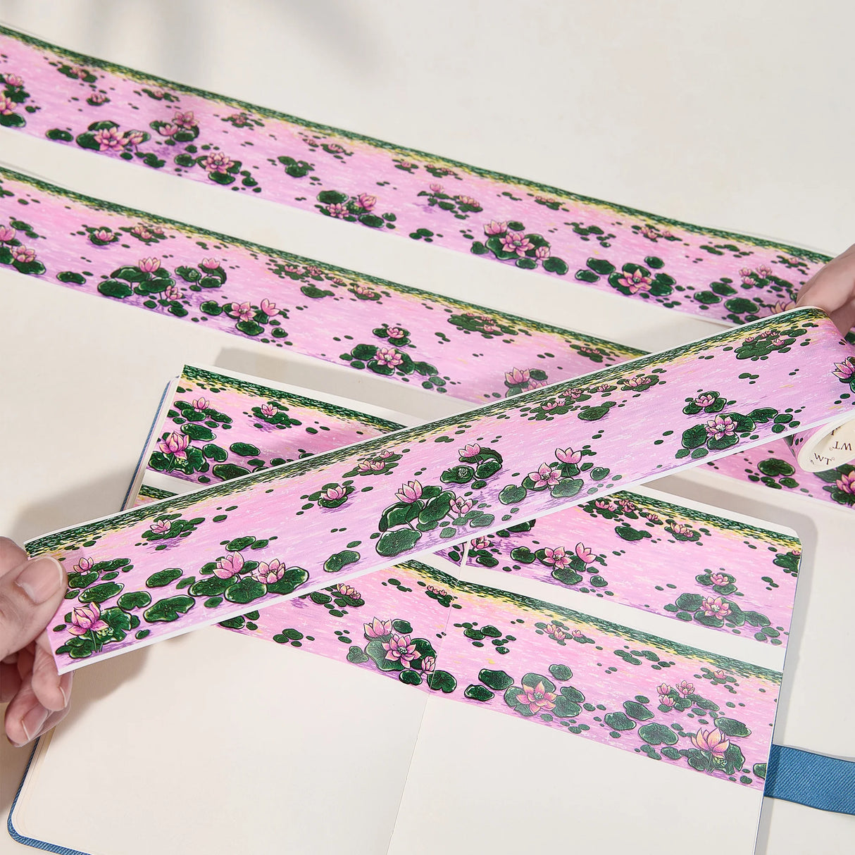 Immerse yourself in the serenity of dusk with the Lotus Silhouette Washi/PET Tape. This tape captures the quietest moment on the pond, right as the sun dips below the horizon. The design features elegant lotuses floating on calm water, their usual bright colors softened into a deep, romantic pink by the fading sunset light. These aren't just flowers; they are reflections of the sky, "blushing" in the twilight.