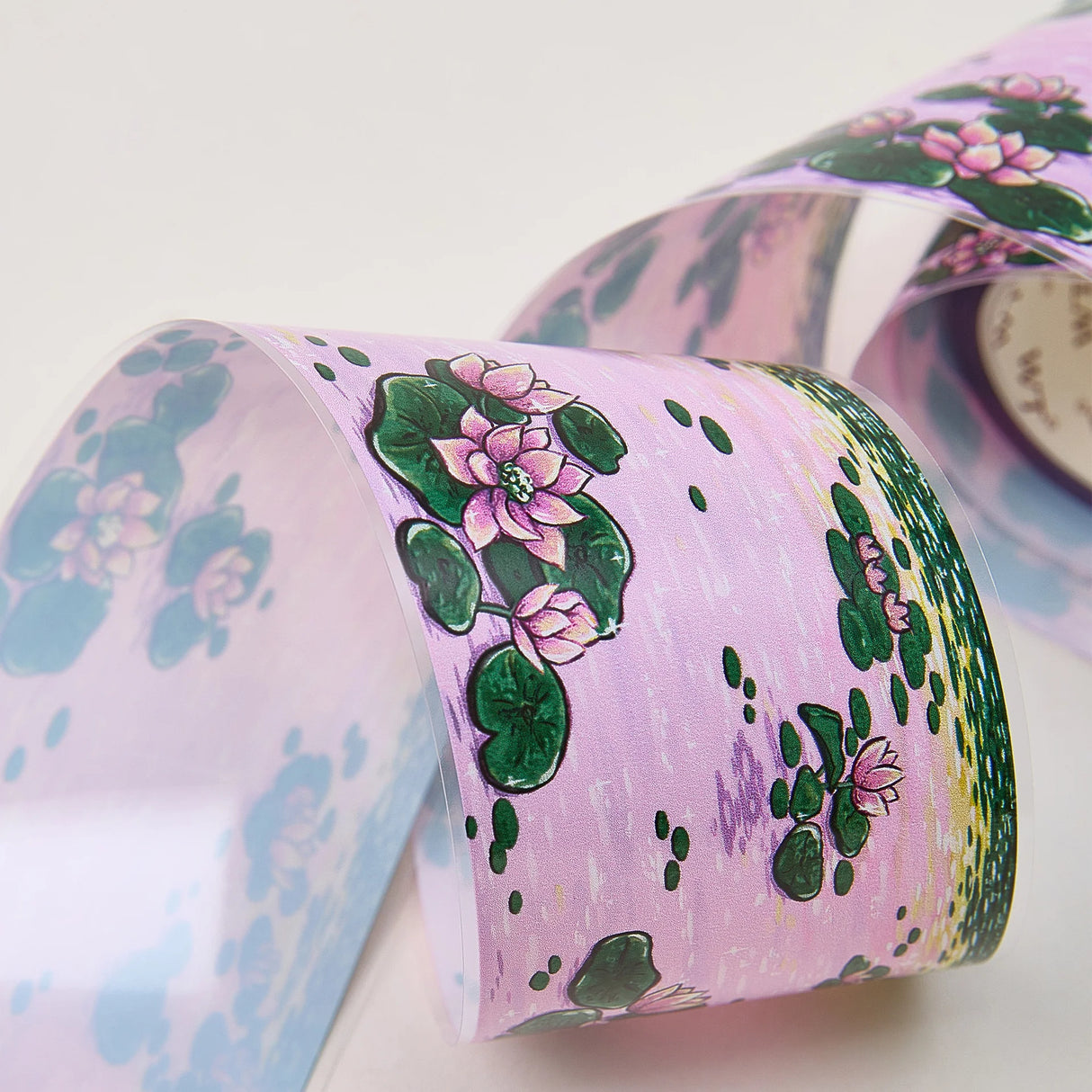 Immerse yourself in the serenity of dusk with the Lotus Silhouette Washi/PET Tape. This tape captures the quietest moment on the pond, right as the sun dips below the horizon. The design features elegant lotuses floating on calm water, their usual bright colors softened into a deep, romantic pink by the fading sunset light. These aren't just flowers; they are reflections of the sky, "blushing" in the twilight.
