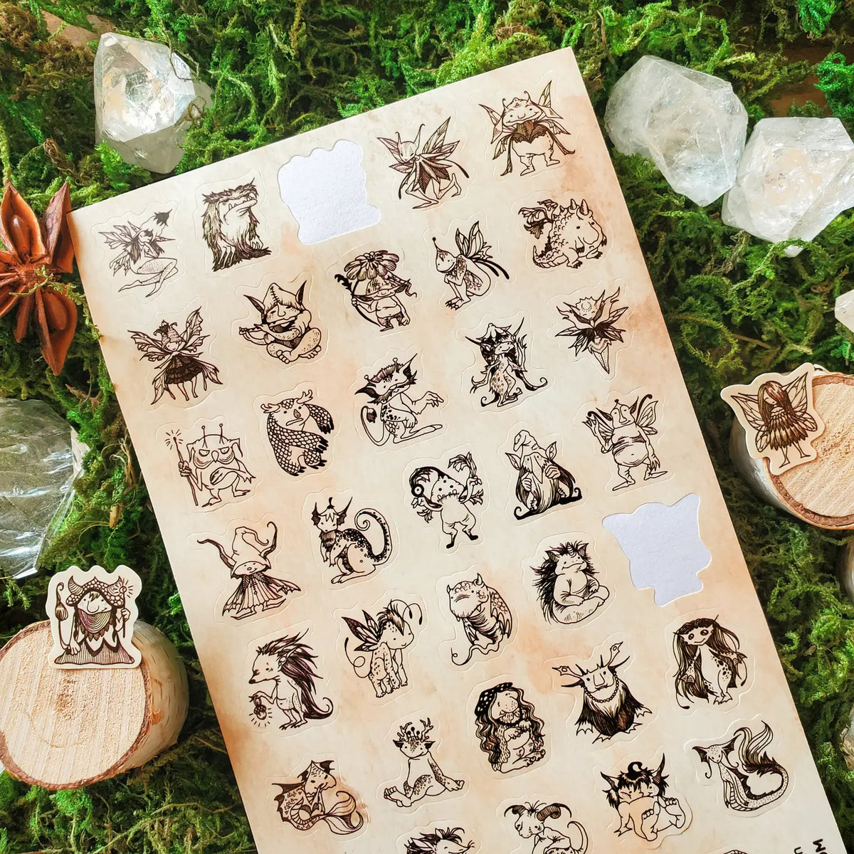 A curious gathering of tiny forest folk fills this sheet, from winged fae and horned creatures to mushroom dwellers, leafy little beings, and a few faces that are wonderfully hard to classify. Delicate sepia linework gives each character its own personality, creating an enchanting collection that feels as though these secretive little residents have been hiding among the moss all along.
One sticker sheet is included.
Top Coating: None
Adhesive Layer: Paper
Backing Layer: Paper
Size: 6.69"x3.54"
Weight-0.3